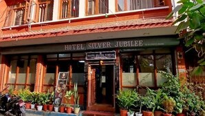 Un hotel llamado 'Hotel Silver Jubilee' con un estilo arquitectónico tradicional, que presenta un tejado de tejas y balcones de madera.