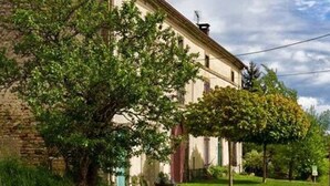 Un edificio con fachada de ladrillo, amplias ventanas y un césped cuidado.