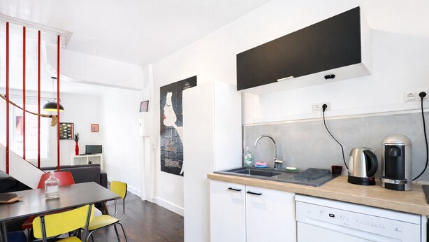 A modern kitchen with a dishwasher, kettle, and coffee machine. - La Maison Créative (La Madeleine)