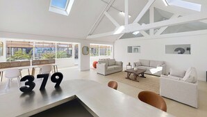 Un amplio salón con techo alto, ventanas grandes y un diseño moderno.