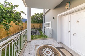 A covered outdoor area with a white door, a decorative tiled floor, and a metal railing. - Daisy Villa Icmeler Marmaris Private (Marmaris)