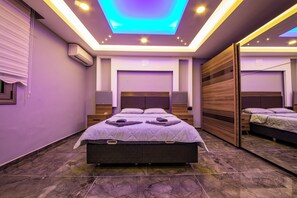 A modern bedroom with a bed, bedside tables, and a ceiling light fixture. - Daisy Villa Icmeler Marmaris Private (Marmaris)