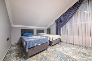 A bedroom with two beds, a marble floor, and a large window with curtains.