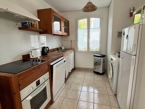 A compact kitchen with a stove, oven, sink, and a washing machine. - Semi-detached house near beach - 5 guests (Sauzon)