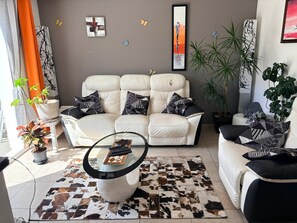 Ein Wohnzimmer mit einer Couch, einem Couchtisch und dekorativen Kissen.