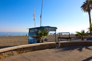 Eine Strandhütte mit einem Schild mit der Aufschrift 'CAYARY', einer Palme und freiem Blick auf das Meer.