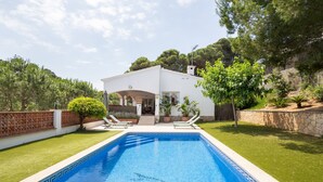 A swimming pool with a white house in the background. - Villa with Pool Just 500 Meters from the Beach (Begur)