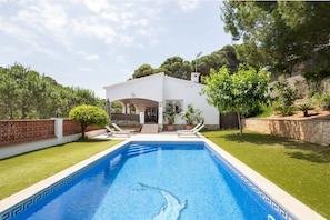 A swimming pool with a white house in the background. - Villa with Pool Just 500 Meters from the Beach (Begur)
