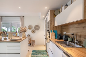 A modern kitchen with a wooden countertop, stainless steel sink, and a built-in oven. - Villa with Pool Just 500 Meters from the Beach (Begur)