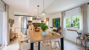 A modern kitchen with a wooden island, pendant lights, and a view of the outdoors. - Villa with Pool Just 500 Meters from the Beach (Begur)