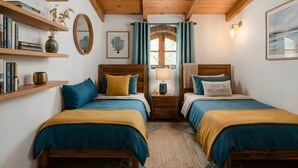 A room with two beds, wooden beams, a window with curtains, a lamp, and shelves with books and a vase.