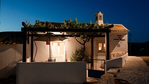 A white building with a pergola, a small garden, and a sign reading 'CASA DE HABLA VENEZUELA.'