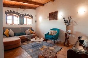 Ein Wohnzimmer mit Sofa, Sessel, Couchtisch und Fernsehmöbel.