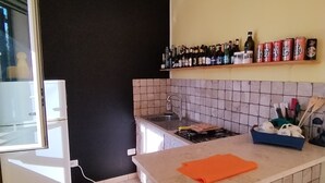 Una cocina con salpicadero de azulejos, encimera, lavabo y refrigerador.