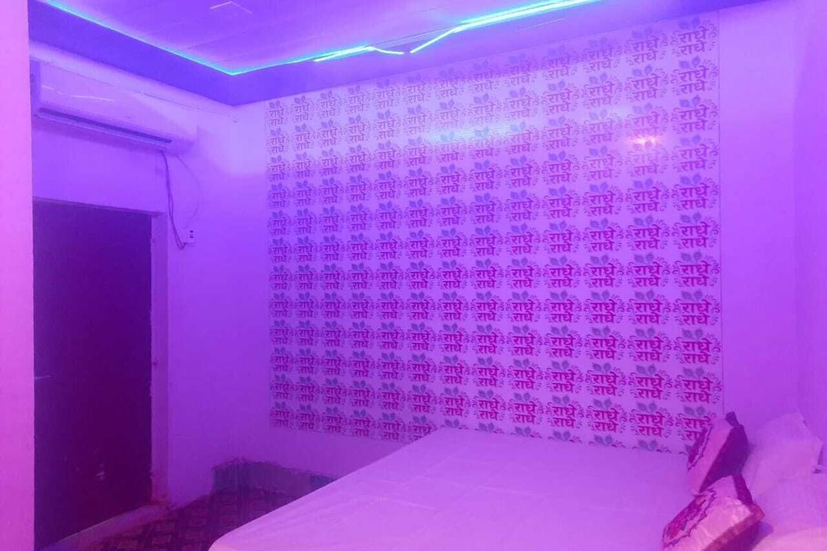 Una habitación con una cama, un papel tapiz decorativo y una puerta.