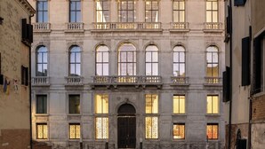 A historic building with a symmetrical facade, large windows, and a central entrance with a dark door. - Viola Suite Luxury Canal View Central Venice (Venezia)