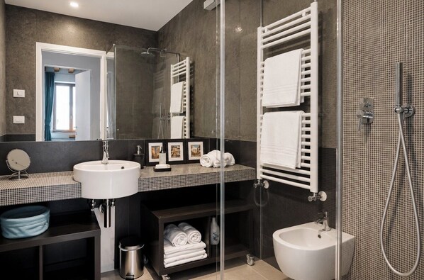 Een moderne badkamer met een douchecabine van glas, een wit wastafelmeubel, een toiletbril en een spiegel.