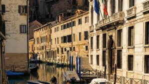 A canal with boats, a building with classical architecture, and flags. - Viola Suite Luxury Canal View Central Venice (Venezia)