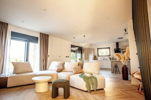 A modern living room with a sofa, ottoman, and coffee table.