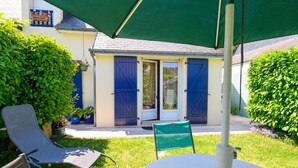 A patio with two chairs, a table, and a green umbrella. - Holiday Home 'Ty Lydian' with Private Terrace, Private Garden and Wi-Fi (Arradon)