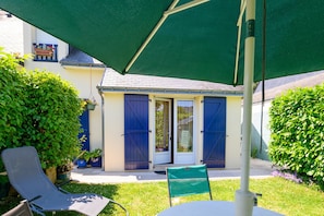 A patio with two chairs, a table, and a green umbrella. - Holiday Home 'Ty Lydian' with Private Terrace, Private Garden and Wi-Fi (Arradon)