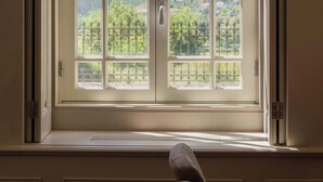A room with a large window, a door, and a view of a landscape. - Private Villa 2 in Noronha Lima Boutique Hotel (Arouca)