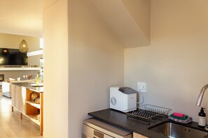 Eine moderne Küche mit integriertem Geschirrspüler, Spüle und Arbeitsplatte.