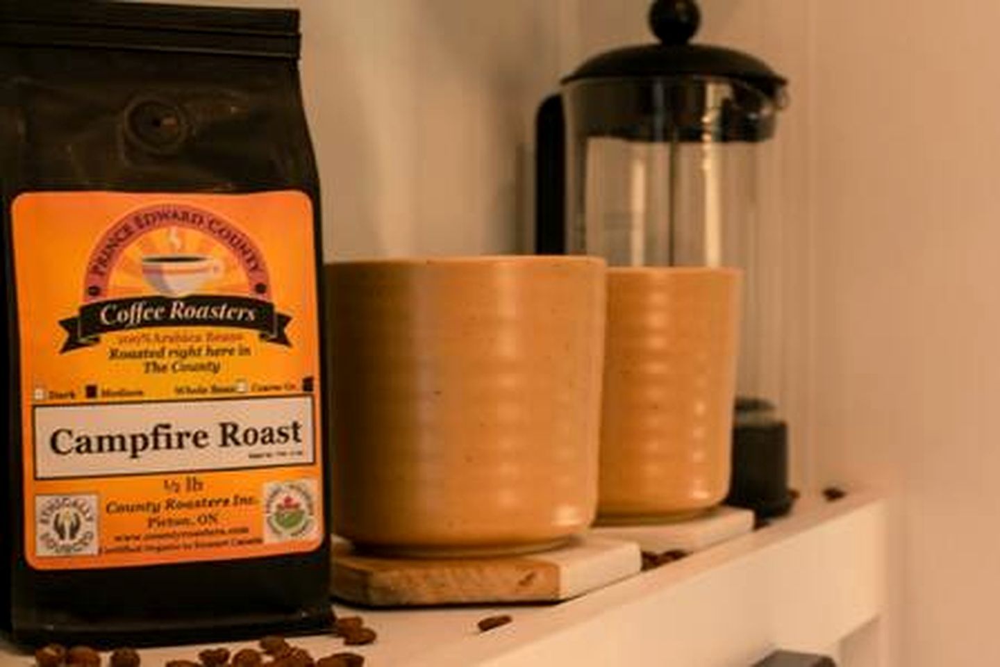 A bag of coffee labeled 'Campfire Roast' and two containers on a shelf.