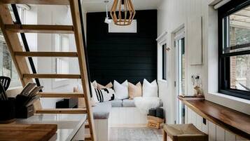 Una habitación con cama de dosel, una escalera de madera, un escritorio y una ventana con vistas.