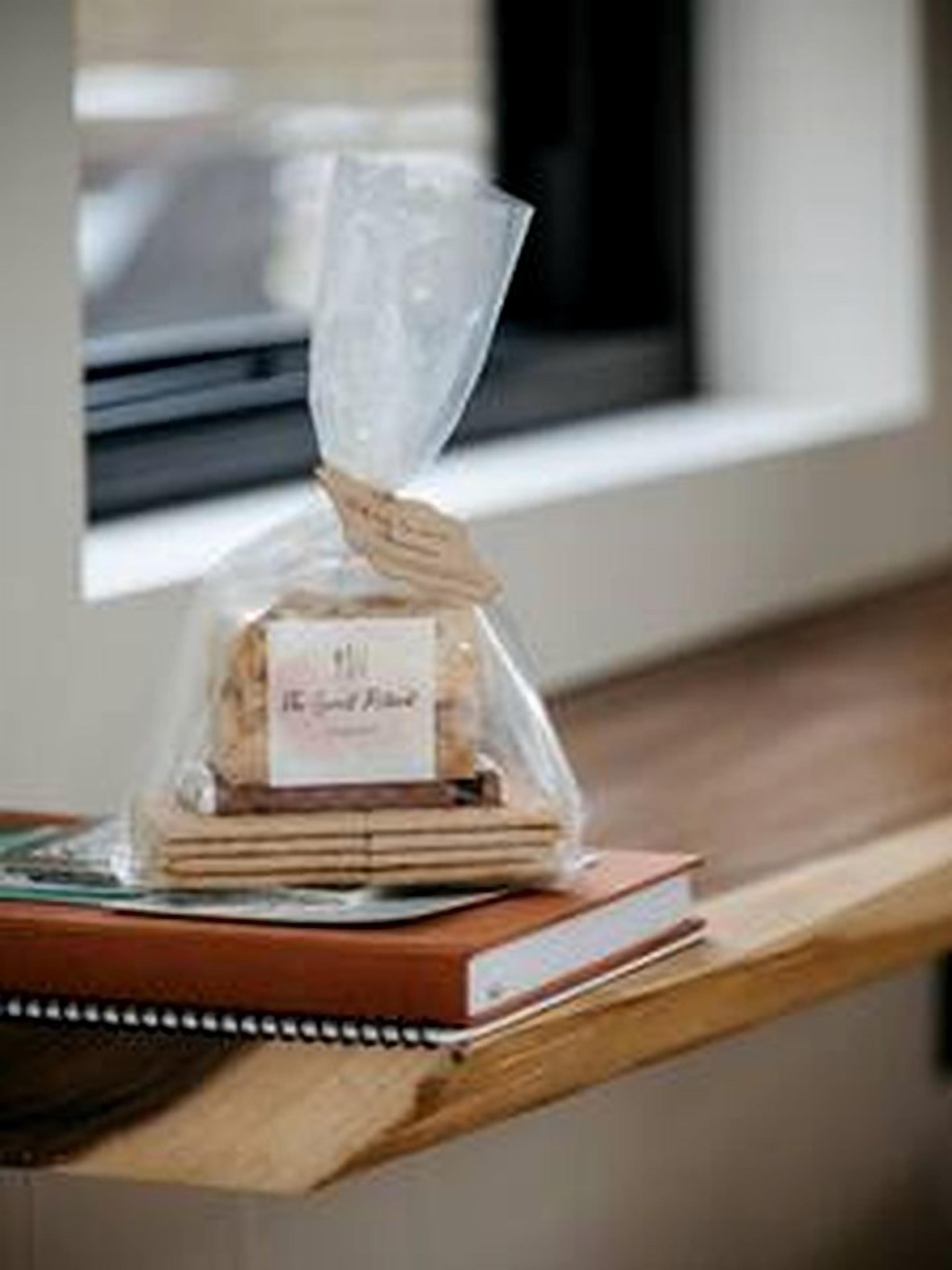 A stack of books on a wooden surface with a clear plastic bag containing a product.