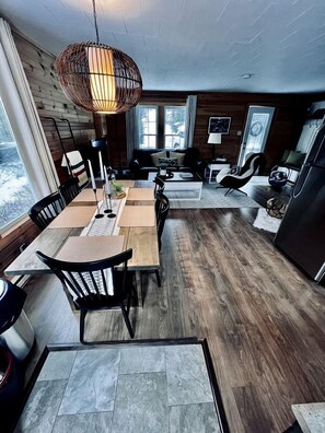 A modern interior with a dining area, kitchen, and seating space. - Picturesque Cottage with Spacious Large Backyard and BBQ in Canada (Brigus South)