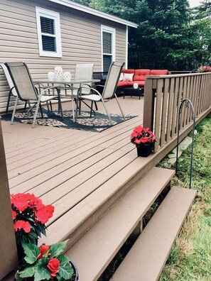 A deck with outdoor furniture, a railing, and potted plants. - Picturesque Cottage with Spacious Large Backyard and BBQ in Canada (Brigus South)