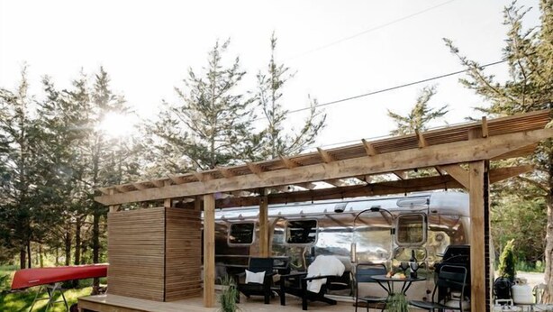A wooden deck with outdoor seating and a grill area.