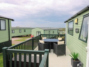 A green mobile home with a balcony, outdoor furniture, and a Marriott sign. - 18 Eden Heights (St. Andrews)