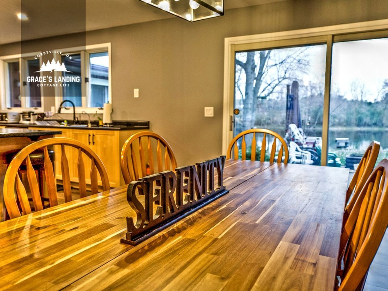 Un coin repas avec une table en bois, des chaises et une pancarte indiquant « Sérénité ».