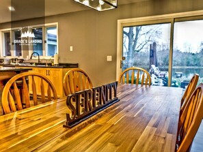 Un coin repas avec une table en bois, des chaises et une pancarte indiquant « Sérénité ».