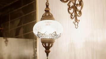 A wall-mounted light fixture with a glass shade and ornate metal design.