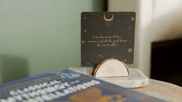A wooden block with a card on top, a book, and a blurred background.