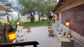 A patio area with outdoor seating, tables, and lanterns. - Twiga Lodge Tiwi (Tiwi)