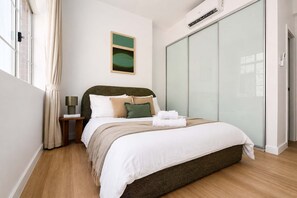 Un dormitorio con cama, mesita de noche y armario.