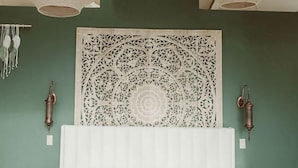 A bedroom with a large bed, a decorative wall panel, and three hanging light fixtures. - Peaceful Boho Dome Escape with Open Field Views in Ontario, Canada (Marmora)
