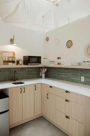 A modern kitchen with a microwave, sink, and wooden cabinets.