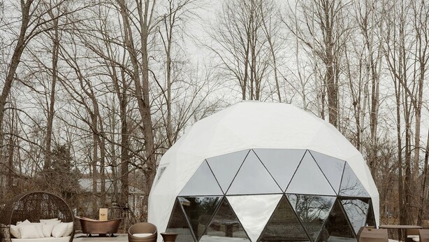A geodesic dome structure with a transparent triangular window design, surrounded by bare trees. - Peaceful Boho Dome Escape with Open Field Views in Ontario, Canada (Marmora)