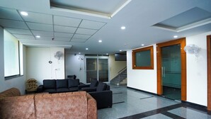 Un hall con un sofá, una mesa de centro, una escalera y una puerta.