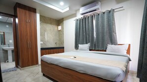 Un dormitorio con cama, armario de madera, baño y equipo de aire acondicionado.