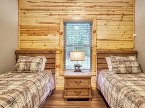 A room with two beds, a nightstand, and a window with blinds. - Secluded 3bdrm/2bth cabin with hiking trail & bonfire pit, Peaceful Path (Townsend)