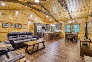 A wooden cabin interior with a living area, kitchen, and dining space. - Secluded 3bdrm/2bth cabin with hiking trail & bonfire pit, Peaceful Path (Townsend)