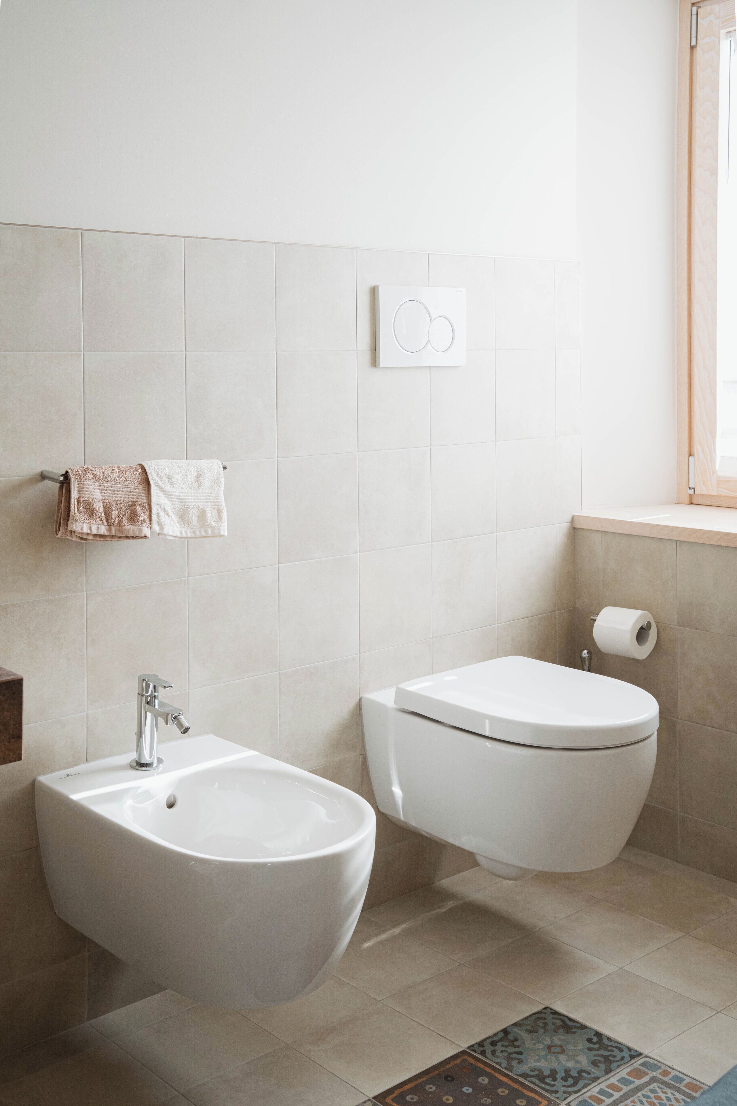 Un baño moderno con bidé, inodoro y toallero.