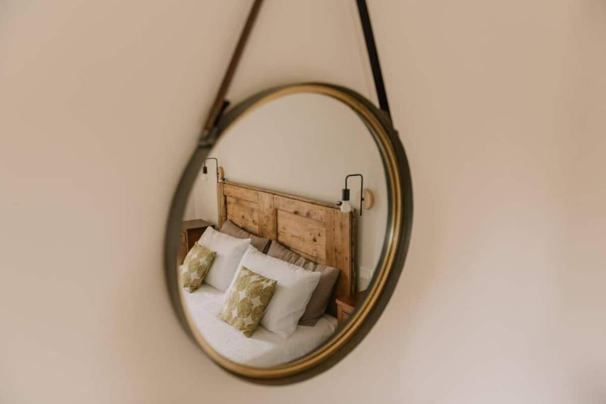 A bed with a wooden headboard and two pillows.