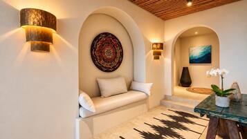 Pause with a book in this shared seating nook, framed by curved alcoves, warm lighting, and decorative art.